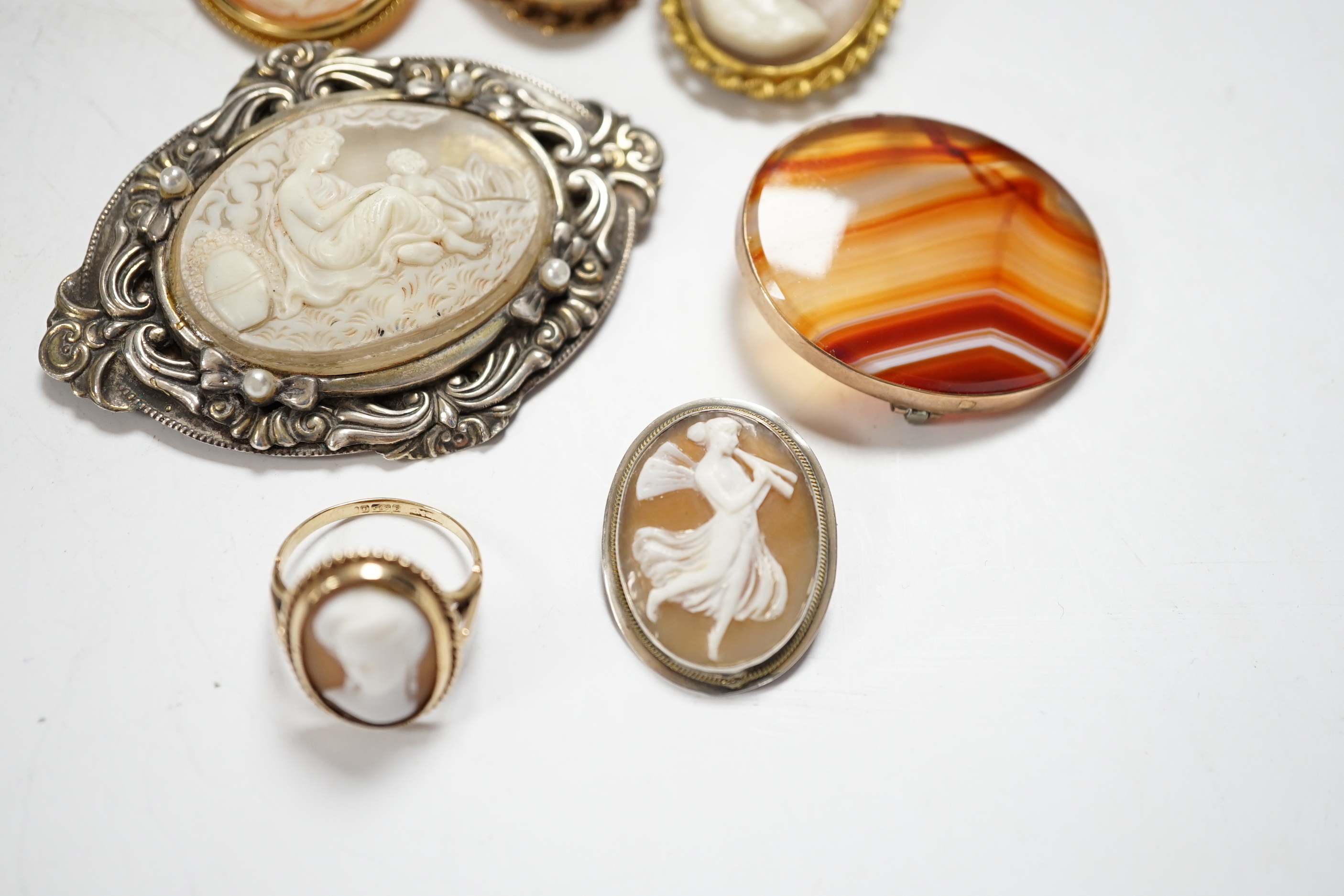 Two modern 9ct gold mounted oval cameo shell brooches, a 9ct gold and cameo shell set ring, three other cameo shell set brooches and a 9ct and banded agate set oval brooch, 40mm.